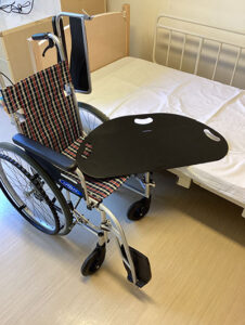 居室内に置かれた車椅子と介護用ベッド。日常的な介護環境を示す。